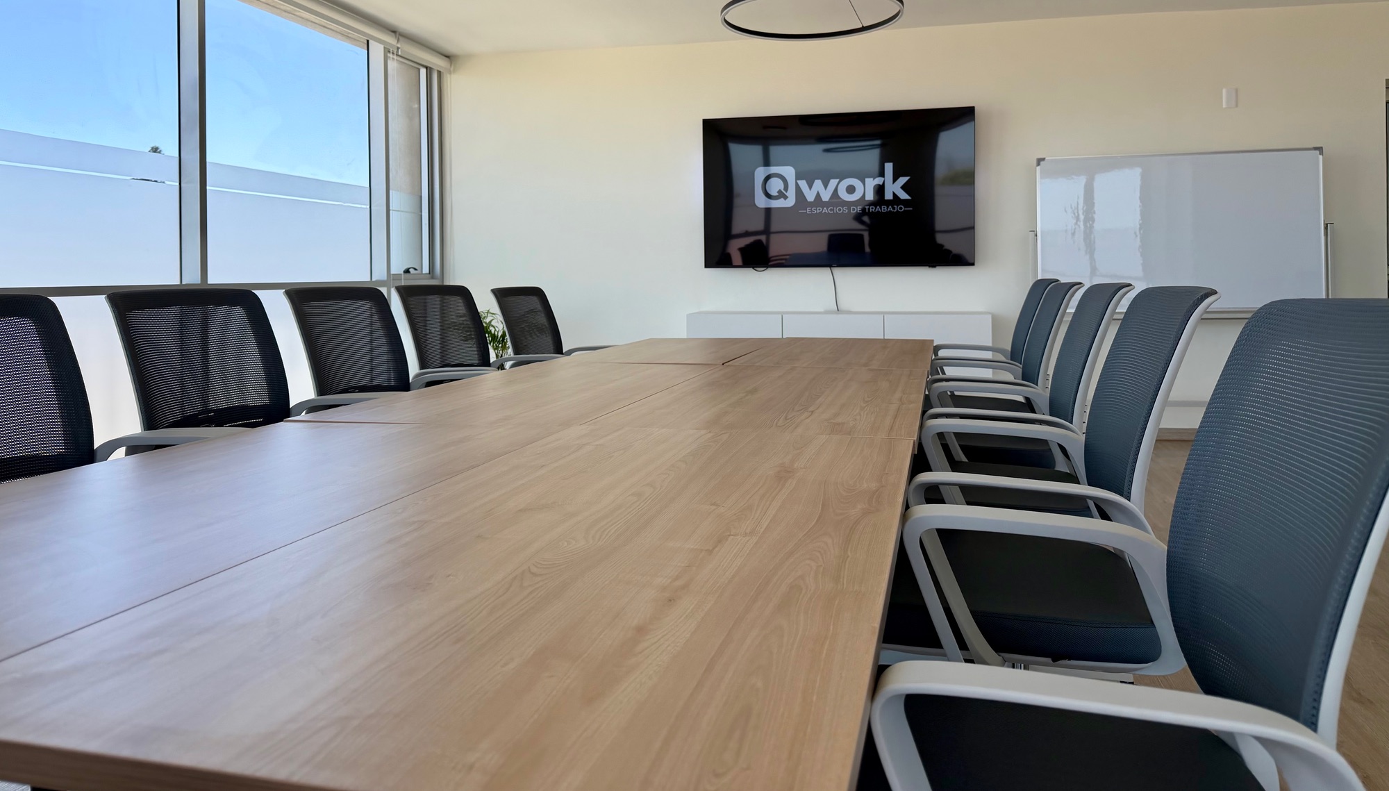 Sala de reuniones QWORK en La Serena, con mesa modular, sillas ergonómicas, TV de 75 pulgadas y luz natural